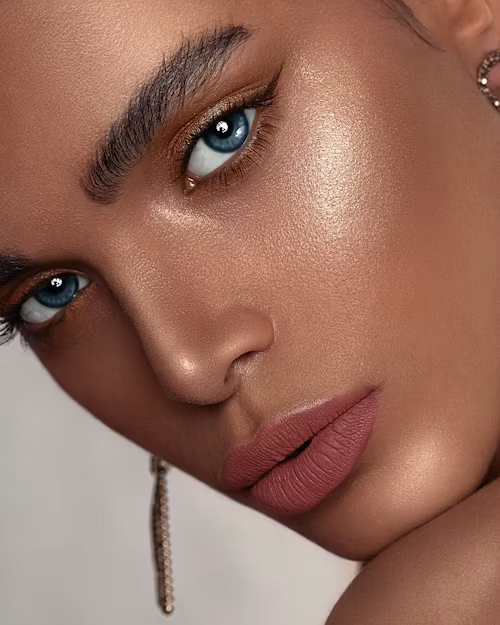 Mulher morena clara com olhos azuis usando maquiagem básica que realça seus traços naturais.
