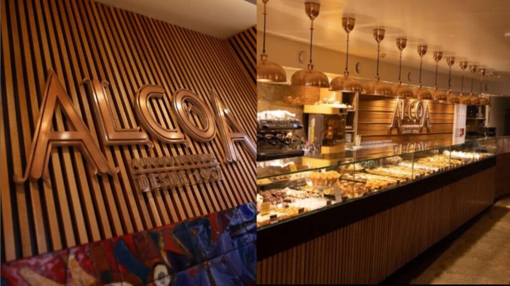 Vitrine da tradicional Cafeteria Alcôa em Portugal com doces típicos portugueses expostos e o logo elegante visível na fachada.